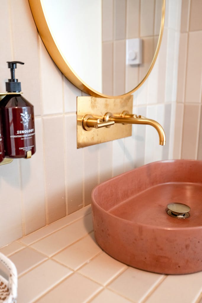 A stylish bathroom vanity featuring a modern golden tap and a chic sink, perfect for contemporary decor.